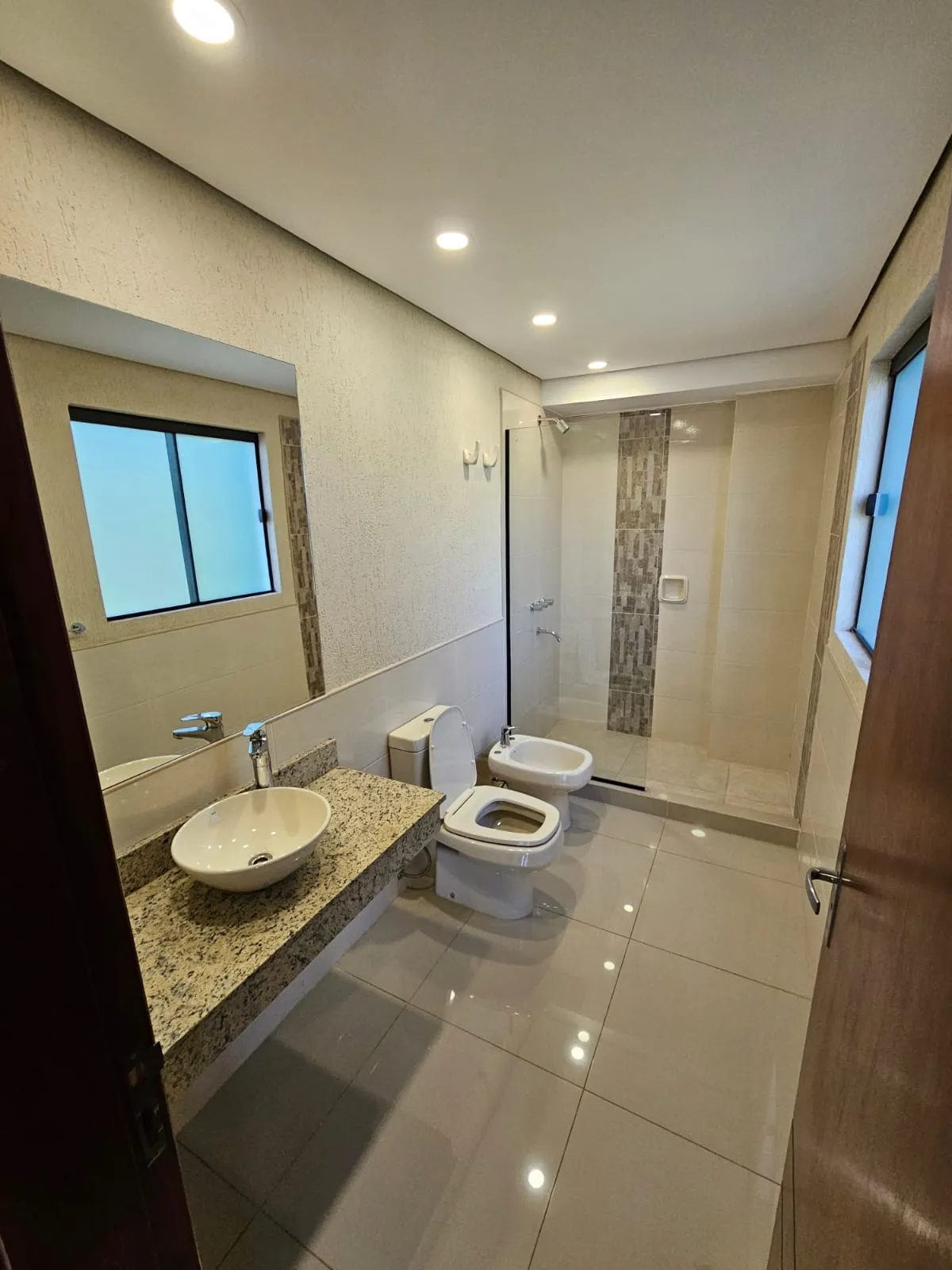 Baño en suite con grifería de alta calidad y mampara